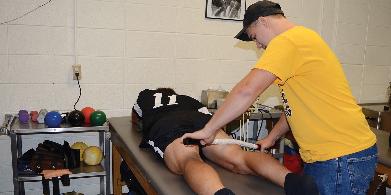 A student athletic trainer treating an athlete.